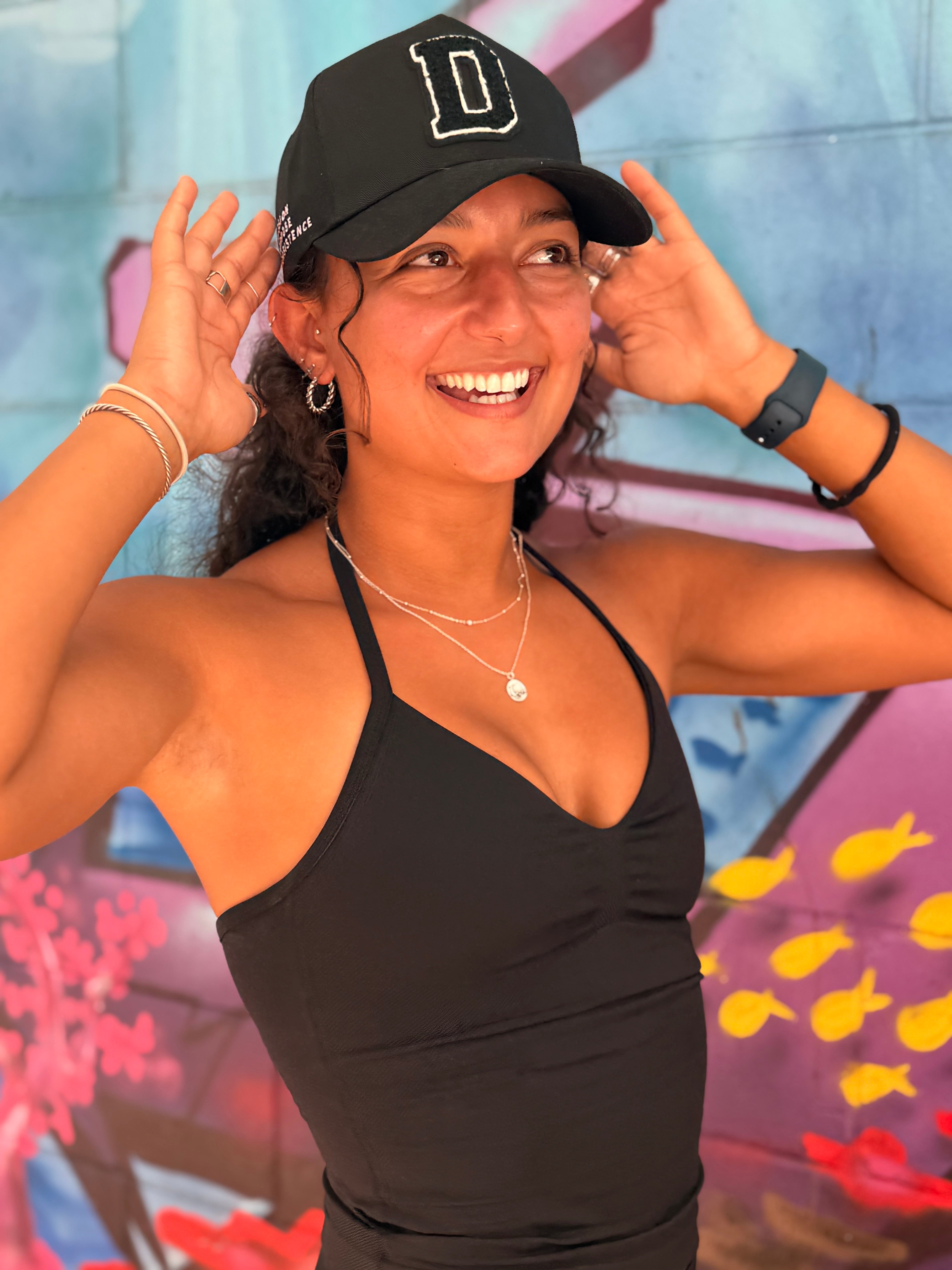 A close-up of resistance bands labeled "DRIVEN GYM APPAREL" in varying shades of black, gray, and beige, with different levels of resistance indicated. They are laid out on a wooden surface next to a black drawstring bag.