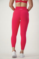 A person is standing with their back to the camera wearing coordinating red activewear: a sports bra and high-waisted Classic Full Length Tights (cherry) featuring "DRIVEN" on the waistband. They're also sporting white athletic shoes, set against a plain white background, from DRIVEN Gym Apparel.